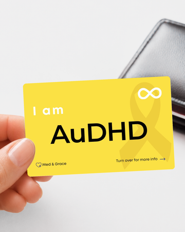 Yellow AuDHD medical alert card for autism and ADHD held in hand