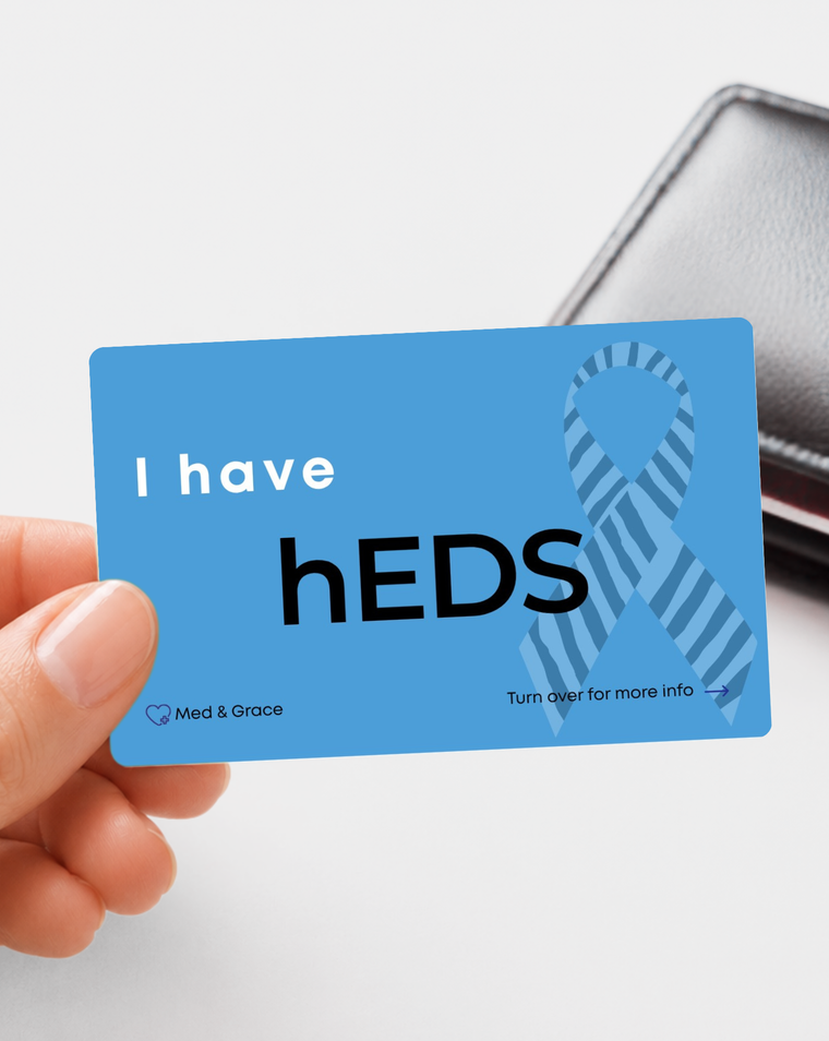 Blue hEDS (Hypermobile Ehlers-Danlos Syndrome) medical alert card held in hand